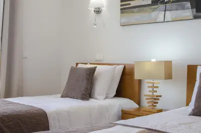 a bedroom with two beds and a table with a lamp at Villa Maresia in Galé