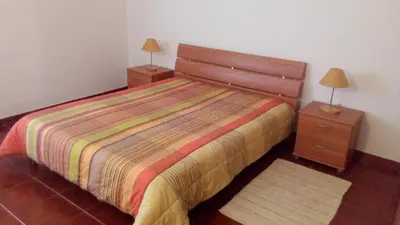 a bedroom with a bed and two night stands at Casal das Alfarrobeiras, 7 in Vilamoura
