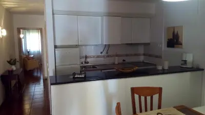 a kitchen with white cabinets and a table in a room at Casal das Alfarrobeiras, 7 in Vilamoura