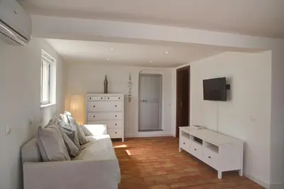a living room with a couch and a dresser at CASA GRAZINA in Boliqueime