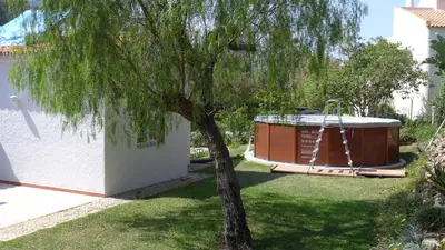 a tree and a hot tub in a yard at Casa Albacor in Vilamoura