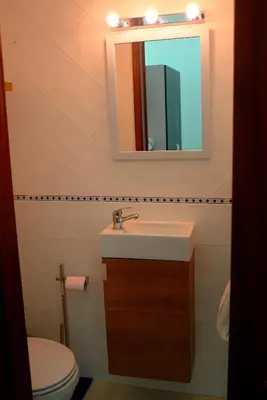 a bathroom with a sink and a mirror and a toilet at Casa Albacor in Vilamoura