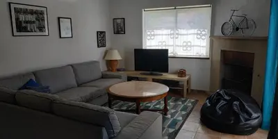 a living room with a couch and a table with a television at Casa Albacor in Vilamoura