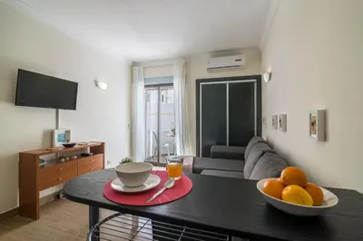 a living room with a table with a bowl of fruit at Albufeira Beach Studio in Albufeira