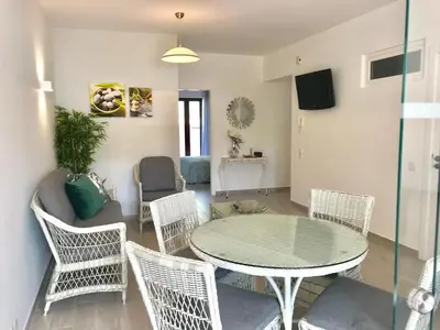 a living room with a glass table and chairs at B2 Marina Vilamoura Apartment in Quarteira