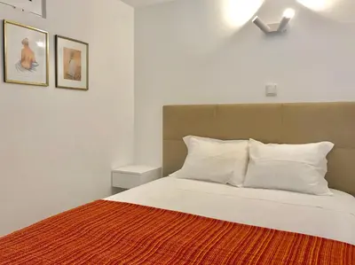 a bedroom with a bed with white sheets and pillows at B2 Marina Vilamoura Apartment in Quarteira