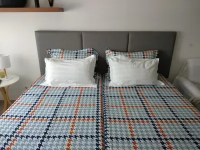 a bed with two pillows and a quilt on it at Estúdio-Gambelas in Faro