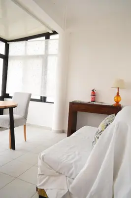 a bedroom with a bed and a table and a window at Estúdio-Gambelas in Faro