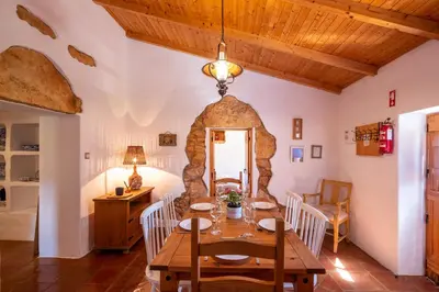 a dining room with a table and a stone wall at Villa Monte Algarvio - Private Heated Pool - wifi in Tunes