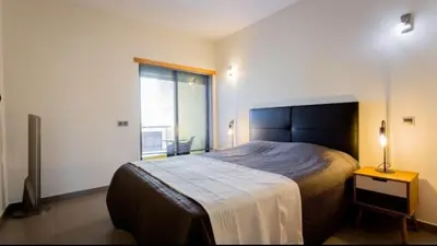 a bedroom with a large bed and a window at Parque Atlântico com Vista Mar in Quarteira