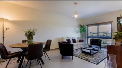 a living room with a table and a couch at Parque Atlântico com Vista Mar in Quarteira