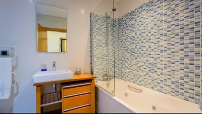 a bathroom with a sink and a glass shower at Parque Atlântico com Vista Mar in Quarteira