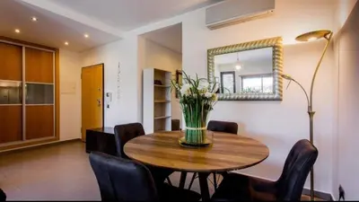 a dining room table with chairs and a vase of flowers at Parque Atlântico com Vista Mar in Quarteira
