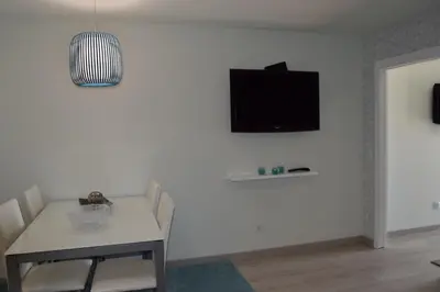 a living room with a table and a tv on a wall at magnifico apartamento in Albufeira