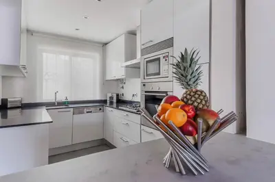 a kitchen with a bowl of fruit on a counter at Beach Design House Sao Rafael in Albufeira