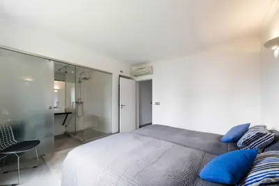 a bedroom with a large bed with blue pillows at Beach Design House Sao Rafael in Albufeira