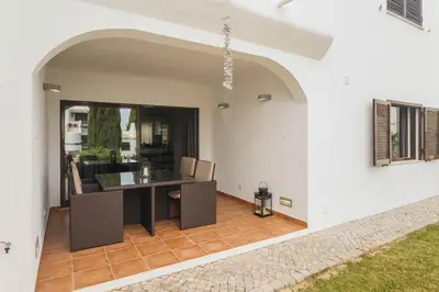 a patio with a table and chairs in a house at Beach Design House Sao Rafael in Albufeira