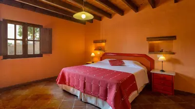 a bedroom with a bed in a room with orange walls at Casinhas Wheelchair friendly in Boliqueime