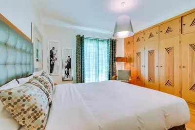a bedroom with a large white bed and wooden cabinets at OnJ Vilamoura in Quarteira