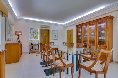 a dining room with a glass table and wooden chairs at OnJ Vilamoura in Quarteira