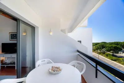 a white dining room with a white table and chairs at WHome | Vilamoura Sunny Apartment in Quarteira