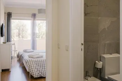 a bedroom with a bed and a bathroom with a window at FLH Falésia Flat with Pool in Vilamoura