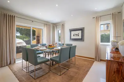a dining room with a table and green chairs at VILLA SIBLING 2 in Vilamoura
