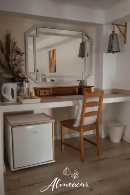 a desk with a chair and a mirror in a room at Guest House Almeixar in Almancil