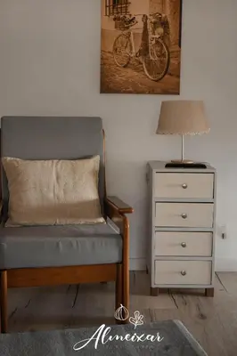 a bedroom with a chair and a lamp and a dresser at Guest House Almeixar in Almancil