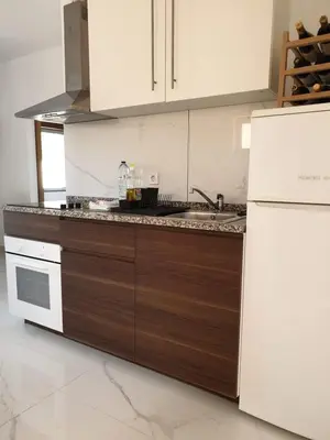 a kitchen with white appliances and brown cabinets at AAA Apartments in Albufeira