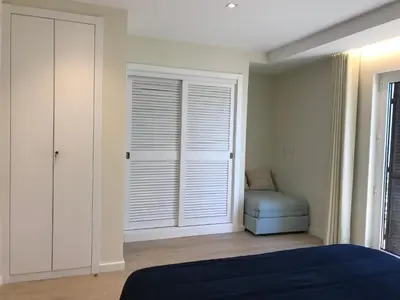 a bedroom with a large window with a blue ottoman at São Rafael Beach Apartment in Albufeira
