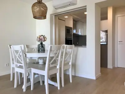 a kitchen and dining room with a white table and chairs at São Rafael Beach Apartment in Albufeira
