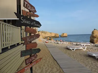 a street sign on a beach with the ocean at São Rafael Beach Apartment in Albufeira