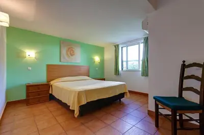 a bedroom with a bed and a chair at CASA MALINDI in Albufeira