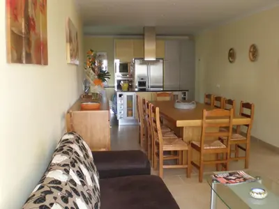 a kitchen and living room with a table and chairs at CASA MALINDI in Albufeira