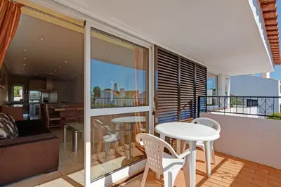 a room with a table and chairs and a balcony at CASA MALINDI in Albufeira