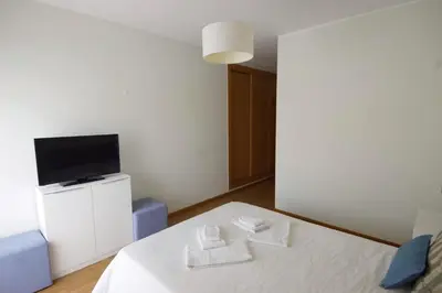 a room with a bed with a tv and towels at Vilamoura Condominio do Pinhal in Vilamoura