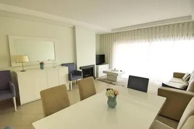 a living room with a table with a vase of flowers on it at Vilamoura Condominio do Pinhal in Vilamoura