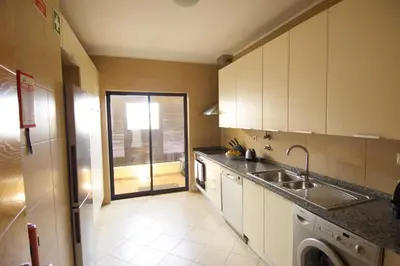 a kitchen with a sink and a washing machine at Vilamoura Condominio do Pinhal in Vilamoura