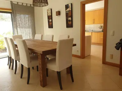 a dining room with a wooden table and white chairs at Albufeira Oura Beach V4 Villa Marisa with private Pool in Albufeira