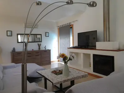a living room with a bed and a table with flowers on it at Albufeira Oura Beach V4 Villa Marisa with private Pool in Albufeira