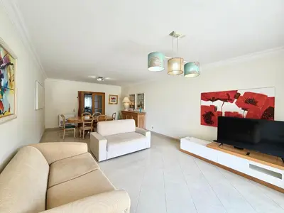 a bedroom with two beds and a window with red curtains at MouraPraia By Garvetur in Vilamoura