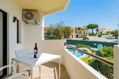 a white table with a bottle of wine on a balcony at Vilamoura new style apt piscina wifi in Vilamoura