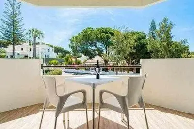 a white table and chairs on a patio at Vilamoura new style apt piscina wifi in Vilamoura