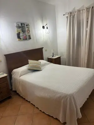 a bedroom with a bed with a white bedspread at Quinta das Nespereiras in Patã de Cima