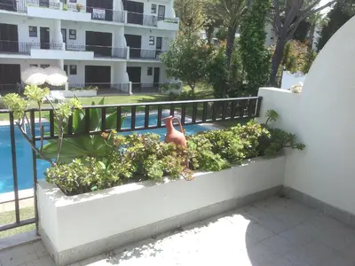 a balcony with plants and a swimming pool at Vilamoura T1 com piscina - Mouramar I in Vilamoura