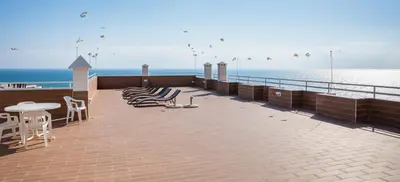 a pier with chairs and tables and the ocean at Apartamentos Mónaco by Garvetur in Albufeira