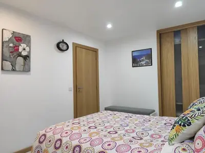 a bedroom with a bed and a clock on the wall at CASA OKSANA in Albufeira