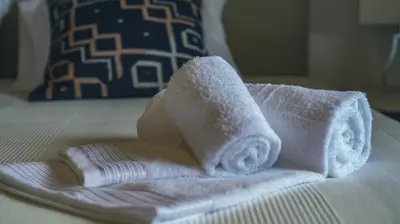 a pile of towels sitting on top of a bed at Pine House - Faro Airport, Beach and City Center in Faro