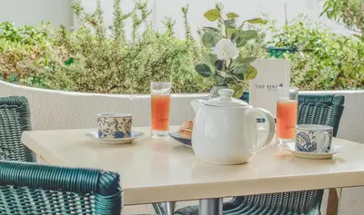 a table with a tea kettle and cups on it at Pine House - Faro Airport, Beach and City Center in Faro